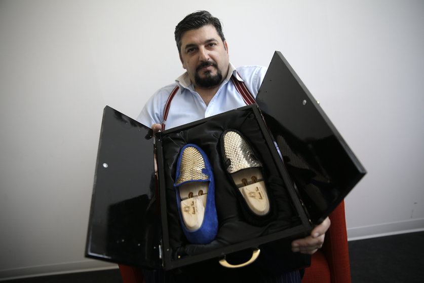 El diseñador italiano Antonio Vietri muestra los zapatos con piezas de oro.