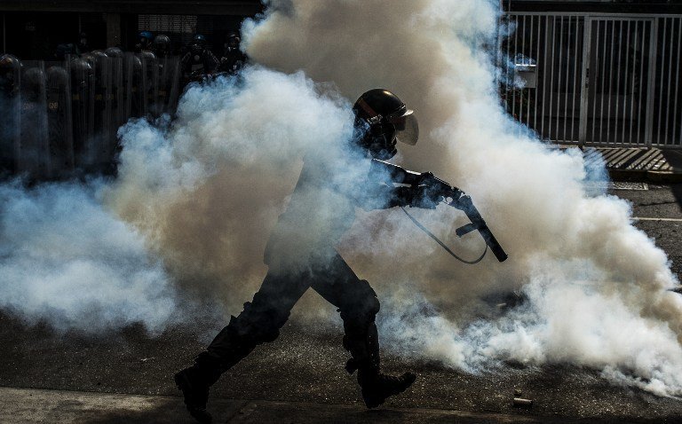 A member of the National Guard cracks down on opposition demonstrators during a march against President Nicolas Maduro, in Caracas on April 26, 2017.
Venezuelan riot police fired tear gas to stop anti-government protesters from marching on central Caracas, the latest clash in a wave of unrest that, up to now, has left 26 people dead. / AFP PHOTO / CARLOS BECERRA