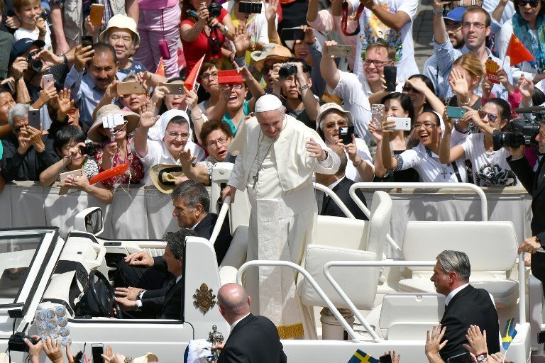 Pope Francis (C) waves to believers from a car during the celebratation of the mass for the imposition of the Pallium upon the new metropolitan archbishops and the solemnity of Saints Peter and Paul on June 29, 2017 in St Peter's square at the Vatican.  / AFP PHOTO / Alberto PIZZOLI