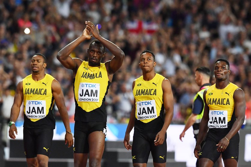 Jamaica's Julian Forte (2R), Yohan Blake (L) and Omar McLeod (R) walk with Jamaica's Usain Bolt (2L) after Bolt pulled up injured in the final of the men's 4x100m relay athletics event at the 2017 IAAF World Championships at the London Stadium in London on August 12, 2017. / AFP PHOTO / Ben STANSALL