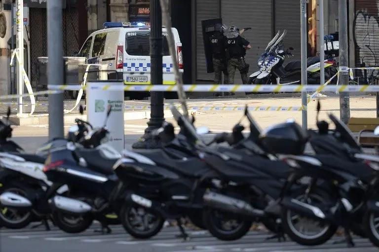 Armed policemen stand in a cordoned off area after a van ploughed into the crowd, killing two persons and injuring several others on the Rambla in Barcelona on August 17, 2017.
A driver deliberately rammed a van into a crowd on Barcelona's most popular street on August 17, 2017 killing at least two people before fleeing to a nearby bar, police said. 
Officers in Spain's second-largest city said the ramming on Las Ramblas was a "terrorist attack" and a police source said one suspect had left the scene and was "holed up in a bar". The police source said they were hunting for a total of two suspects. / AFP PHOTO / Josep LAGO