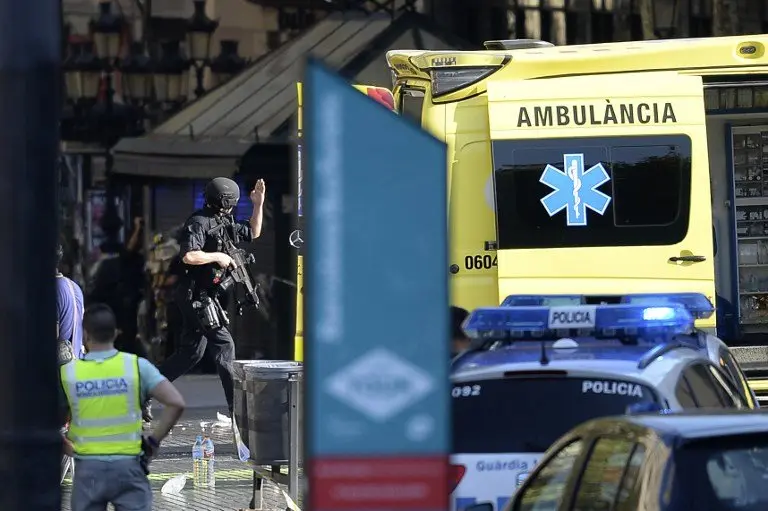 An armed policeman arrives in a cordoned off area after a van ploughed into the crowd, injuring several persons on the Rambla in Barcelona on August 17, 2017.
Police in Barcelona said they were dealing with a "terrorist attack" after a vehicle ploughed into a crowd of pedestrians on the city's famous Las Ramblas boulevard on August 17, 2017. Police were clearing the area after the incident, which has left a number of people injured. / AFP PHOTO / Josep LAGO
