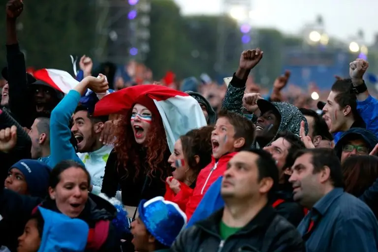 <p>Hinchas franceses que llegaron a la 'fanzone' ubicada al pie de la Torre Eiffel, sobre el Campo de Marte, en Par&iacute;s el 3 de julio de 2016, celebran la goleada 5-2 de su selecci&oacute;n sobre Islandia, en cuartos de final de la Eurocopa 2016.</p>