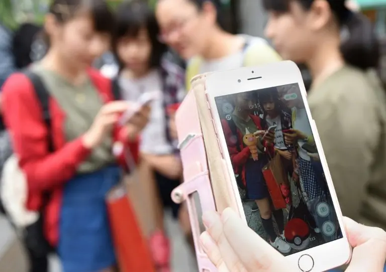 <p>Estudiantes japoneses juegan a Pok&eacute;mon Go en su tel&eacute;fonos m&oacute;viles, el 22 de julio de 2016 en Tokio</p>