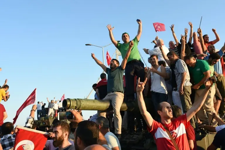 <p>Gente se sube a un tanque de guerra tras haber conquistado una posici&oacute;n militar en el puente del B&oacute;sforo el Estambul el 16 de julio de 2016</p>