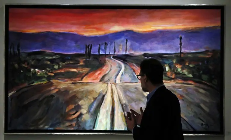 Paul Green, President and Founder of Halcyon Gallery, stands in front of Bob Dylan's painting "Endless Highway" at the Halcyon Gallery during a preview of his artwork in London on November 4, 2016.
Bob Dylan, music legend and Nobel laureate, is also a prolific painter whose works depicting the landscapes and culture of America are the focus of a major London exhibition opening Saturday, November 5, 2016. / AFP PHOTO / ADRIAN DENNIS / RESTRICTED TO EDITORIAL USE - MANDATORY MENTION OF THE ARTIST UPON PUBLICATION - TO ILLUSTRATE THE EVENT AS SPECIFIED IN THE CAPTION