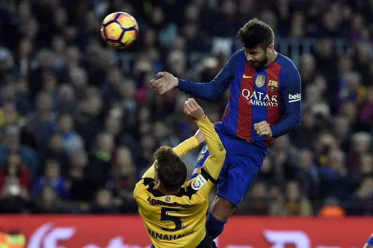 Barcelona's defender Gerard Pique (R) heads the ball past Malaga's midfielder Mikel during the Spanish league football match FC Barcelona vs Malaga CF at the Camp Nou stadium in Barcelona, on November 19, 2016. / AFP PHOTO / LLUIS GENE