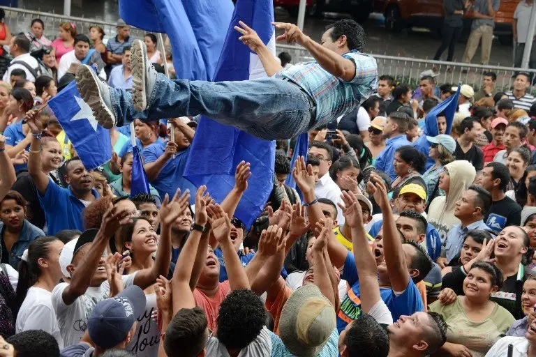 Supporters of Honduran President Juan Orlando Hernandez celebrate in Tegucigalpa, on December 14, 2016. 
The Supreme Electoral tribunal (TSE) authorized Hernandez to present his candidacy to the reelection. / AFP PHOTO / ORLANDO SIERRA
