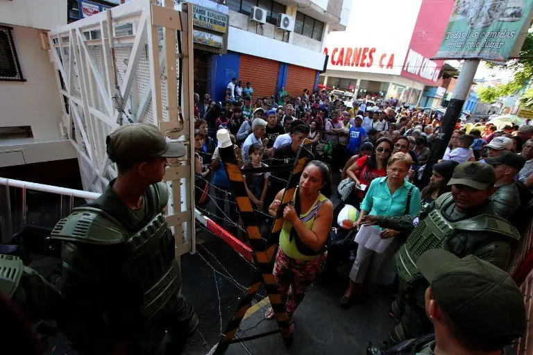 Bolivarian National Guard members control the access to the Simon Bolivar international bridge -which links the city with Cucuta, in Norte de Santander province, Colombia- in San Antonio del Tachira, Venezuela, on December 17, 2016.
President Nicolas Maduro had ordered the 100-bolivar unit to be scrapped -to combat what he called a US-backed plot against Venezuela- and scheduled to start releasing new higher-denomination notes. He ordered the Colombia border to be closed for three days, saying this would stop the "international gangs" depositing their hoarded banknotes. In Tachira, the crackdown caused added misery for people who rely on cross-border trade. / AFP PHOTO / George Castellanos