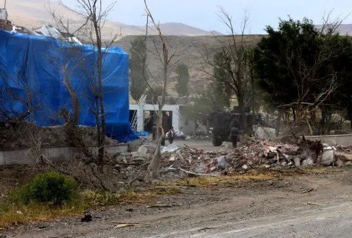 Wreckage lies on the ground in front of a Turkish millitary station covered by a tarpaulin after a suicide atack on August 2, 2015  in east Turkey town Dogubeyazit in Agri Province. Two Turkish soldiers were killed and 24 wounded in a suicide bombing blamed on militants of the outlawed Kurdistan Workers Party (PKK) on their local headquarters in eastern Turkey, reports said. AFP PHOTO /STRINGER / AFP PHOTO / STR