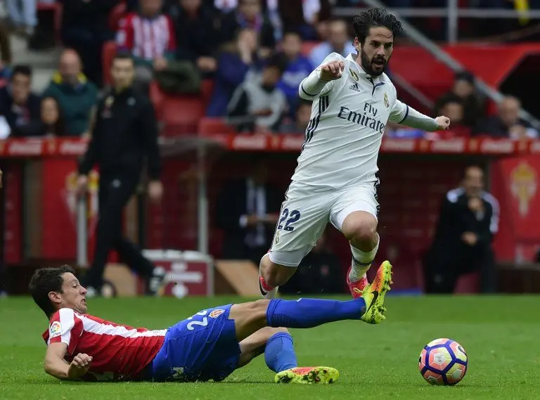 Real Madrid's midfielder Isco (R) controls the ball next to Sporting Gijon's midfielder Mikel Vesga during the Spanish league football match Real Sporting de Gijon vs Real Madrid CF at El Molinon stadium in Gijon on April 15, 2017. / AFP PHOTO / MIGUEL RIOPA