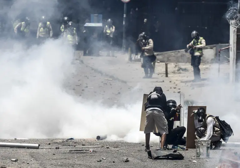 Demonstrators clash with the police during a rally against Venezuelan President Nicolas Maduro, in Caracas on April 19, 2017. 
Venezuela braced for rival demonstrations Wednesday for and against President Nicolas Maduro, whose push to tighten his grip on power has triggered waves of deadly unrest that have escalated the country's political and economic crisis. / AFP PHOTO / JUAN BARRETO