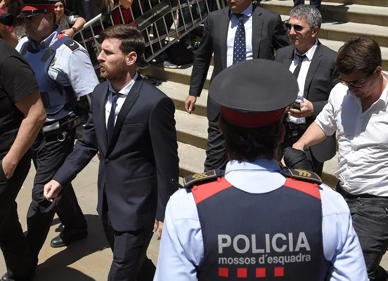 (FILES) This file photo taken on June 2, 2016 shows 
Barcelona's football star Lionel Messi (L), followed by his father, leaving the courthouse in Barcelona.
A Spanish court said today it has replaced with fines the suspended prison sentences handed down to FC Barcelona's star striker Lionel Messi and his father. / AFP PHOTO / LLUIS GENE
