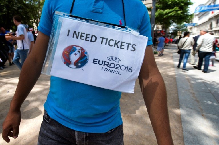 <p>Un hombre camina con un cartel en el que pide entradas para la Eurocopa, el 20 de junio de 2016 en Saint-Etienne</p>