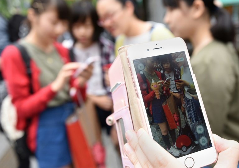 <p>Estudiantes japoneses juegan a Pokémon Go en su teléfonos móviles, el 22 de julio de 2016 en Tokio</p>