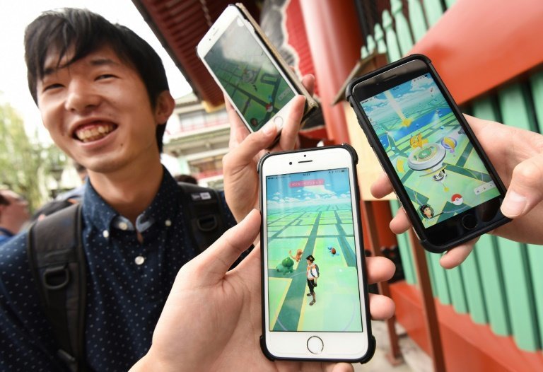 <p>Unos estudiantes japoneses muestras sus teléfonos móviles con el el juego Pokemon Go este viernes 22 de julio en Tokio</p>