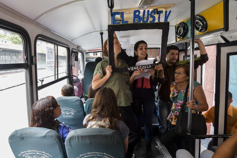 Laura Castillo (L), Maria Gabriela Fernandez (C) and Dereck Blanco (R) give a presentation of the Bus TV news in Caracas, Venezuela, on June 6, 2017.
A group of young Venezuelan reporters board buses to present the news, as part of a project to keep people informed in the face of what the opposition and the national journalists' union describe as censorship by the government of Nicolas Maduro. / AFP PHOTO / LUIS ROBAYO