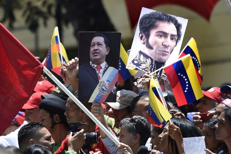 Government supporters carry images of late Venezuelan President Hugo Chavez (L) and Venezuelan Liberator Simon Bolivar during a rally in Caracas on the day of the installation of the Constituent Assembly on August 4, 2017.
Venezuelan President Nicolas Maduro was set to install a powerful new assembly packed with his allies Friday, dismissing an international outcry and opposition protests saying he is burying democracy in his crisis-hit country. / AFP PHOTO / JUAN BARRETO