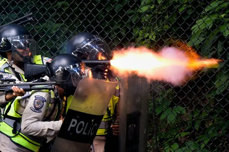 <p>Policías antidisturbios lanzan balas de goma y gases lacrimógenos a estudiantes de la Universidad Central de Venezuela que se manifestaban reclamando el revocatorio al presidente Maduro, el 9 de junio en Caracas</p>