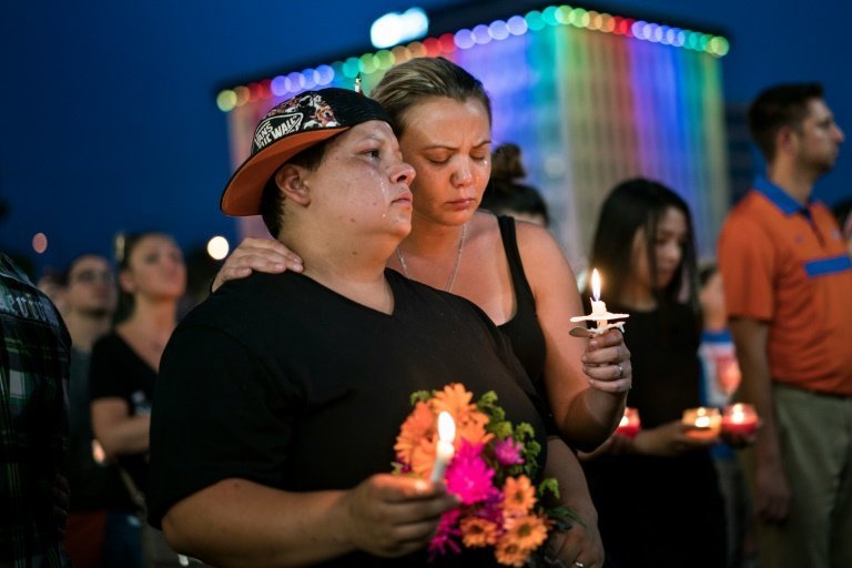 <p>Una pareja homosexual observa un minuto de silencio en memoria de las víctimas de la matanza en la discoteca Pulse, el 13 de junio de 2016 en Orlando (Florida, EEUU)</p>