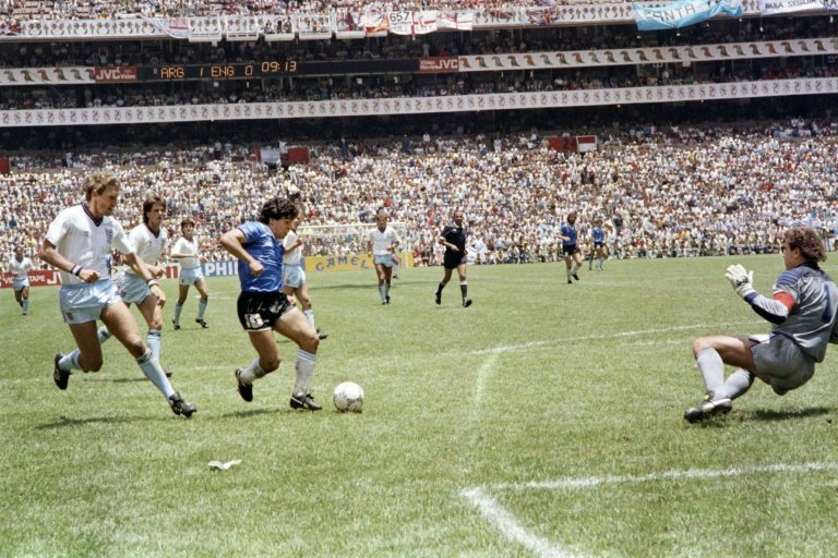 <p>Diego Maradona enfrenta al portero inglés Peter Shilton (D) para marcar un gol antológico en la historia de los mundiales, en partido semifinal de la Copa del Mundo de México-1986, el 22 de junio en Ciudad de México</p>