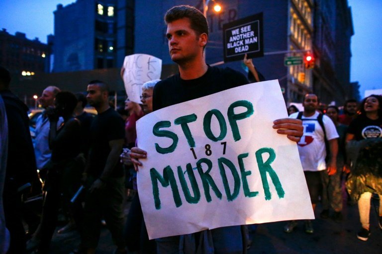 <p>Un hombre con una pancarta que reza "Paren los asesinatos", en una protesta en Nueva York contra la violencia racial, el 9 de julio de 2016</p>
