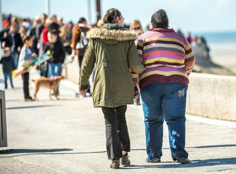 <p>Una persona obesa camina junto a otra por la localidad costera de Berck-sur-Mer, el pasado 12 de abril al norte de Francia</p>
