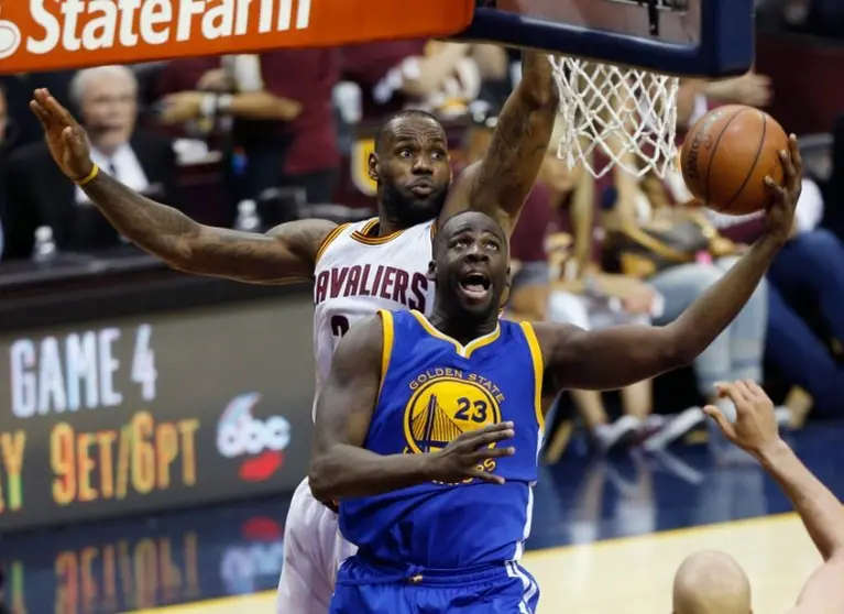 <p>Draymond Green (D), de Golden State Warriors, penetra ante la marca de LeBron James (I), de Cleveland Cavaliers, en el tercer partido de la final de la NBA disputado Cleveland, Ohio, el 8 de junio de 2016</p>