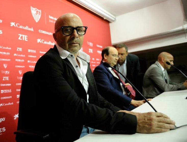 <p>El argentino Jorge Sampaoli (I) mira la cámara antes de una conferencia de prensa para su presentación oficial como DT del Sevilla FC, en el estadio Ramón Sánchez Pizjuán, en Sevilla, el 3 de julio de 2016.</p>