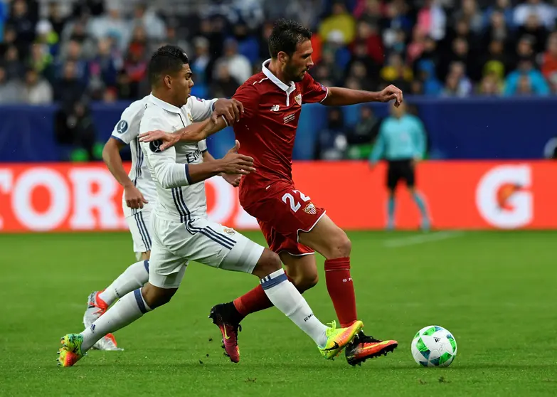 Real Madrid's French defender Raphael Varane (L) and Sevilla's Argentinian midfielder Franco Vazquez vie for the ball during the UEFA Super Cup final football match between Real Madrid CF and Sevilla FC on August 9, 2016 at the Lerkendal Stadium in Trondheim. / AFP PHOTO / JONATHAN NACKSTRAND