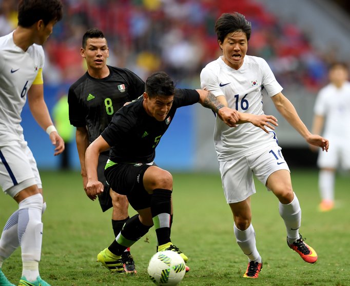 Korea Republic's player Kwon Chang-Hoon (R) vies for the ball with Mexico's player Michael Perez (C) during the Rio 2016 Olympic Games first Round Group C men's football match Korea Republic vs Mexico, at the Mane Garrincha Stadium in Brasilia on August 10, 2016. / AFP PHOTO / EVARISTO SA