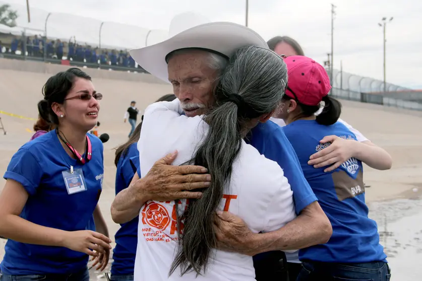 Mexicans hug each other during an event called "Hugs, No Walls" in front of the border fence separating Mexico from the US, in Ciudad Juarez, Chihuahua State, Mexico on August 10, 2016. 
For two minutes there were no walls for 250 families of undocumented immigrants in the United States who joined in an embrace with their siblings, parents and children from different parts of Mexico, in the center of the Rio Bravo. / AFP PHOTO / HERIKA MARTINEZ