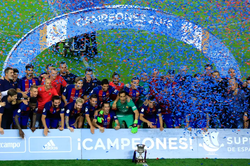 FC Barcelona celebrate with the trophy after winning the second leg of the Spanish Supercup football match between FC Barcelona and Sevilla FC at the Camp Nou stadium in Barcelona on August 17, 2016. / AFP PHOTO / PAU BARRENA