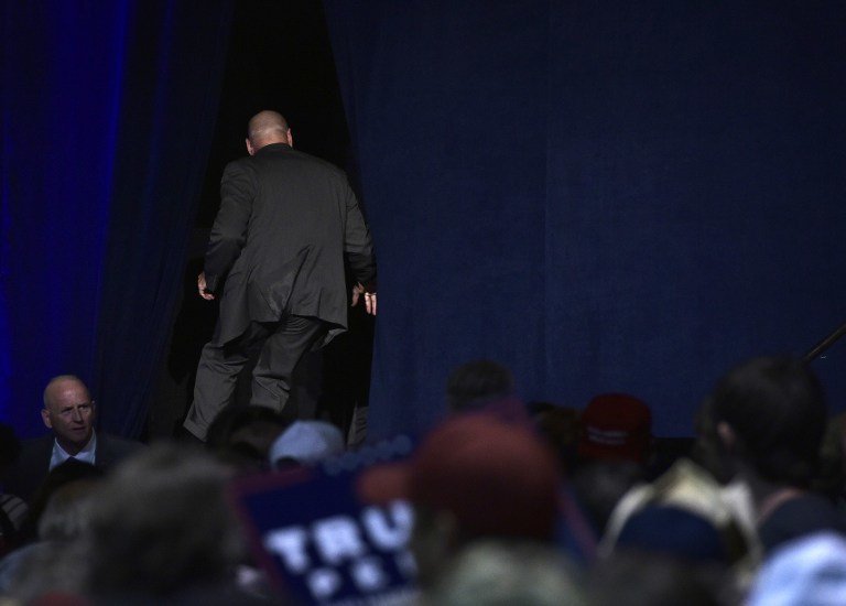 Security personnel rush off stage after Republican presidential nominee Donald Trump was escorted away during a rally at the Reno-Sparks Convention Center in Reno, Nevada on November 5, 2016. / AFP PHOTO / MANDEL NGAN
