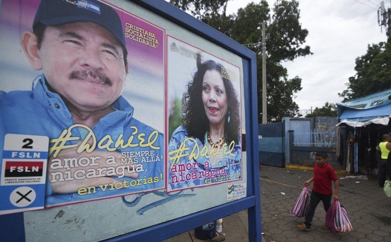 A boy walks next to propaganda of Nicaraguan President Daniel Ortega and her wife Rosario Murillo in Managua on November 2, 2016, ahead of the general elections to take place next November 6.
Surveys indicate that Nicaragua's first couple are more than likely to emerge the winners of elections that will hand Ortega a fourth mandate, and Murillo her first as his vice president. / AFP PHOTO / RODRIGO ARANGUA
