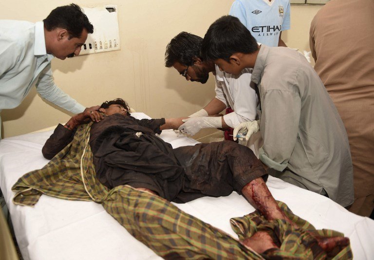 Pakistani paramedics give treatment to an injured blast victim at a hospital in the Hub district, some 40 kilometers from Karachi, on November 12, 2016. 
At least 43 people died and scores of others were injured when a bomb exploded at a remote Sufi shrine in southern Pakistan's restive Balochistan province on November 12, officials said. The blast hit a crowd of worshippers participating in a ceremony at the shrine of Sufi saint Shah Noorani in Khuzdar district, some 760 kilometres south of provincial capital Quetta. / AFP PHOTO / ASIF HASSAN