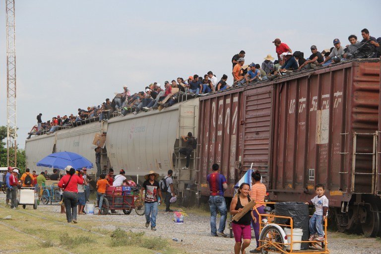 Central American immigrant get on the so-called La Bestia (The Beast) cargo train, in an attempt to reach the Mexico-US border, in Arriaga, Chiapas state, Mexico on July 16, 2014.  AFP PHOTO/ELIZABETH RUIZ / AFP PHOTO / ELIZABETH RUIZ