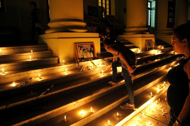 Students light candles in honour of Cuban historic revolutionary leader Fidel Castro a day after his death, at the Havana University in Havana on November 26, 2016. 
Cuban revolutionary icon Fidel Castro died late Friday in Havana, his brother, President Raul Castro, announced on national television. Castro&#39;s ashes will be buried in the historic southeastern city of Santiago on December 4 after a four-day procession through the country. / AFP PHOTO / Yamil LAGE