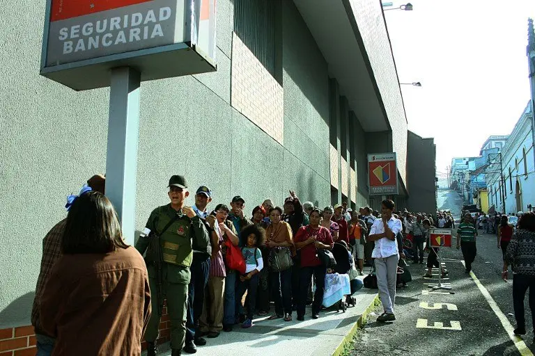 People queue up outside a bank in San Cristobal in an attempt to deposit money, on December 13, 2016.
Venezuelan President Nicolas Maduro ordered on December 12 the border with Colombia sealed for 72 hours, accusing US-backed "mafias" of conspiring to destabilize his country's economy by hoarding bank notes. The closure came a day after Maduro signed an emergency decree removing Venezuela's largest bank note, the 100 bolivar bill, from circulation because of what he called a Washington-sponsored plot against his country's troubled economy. / AFP PHOTO / George CASTELLANOS