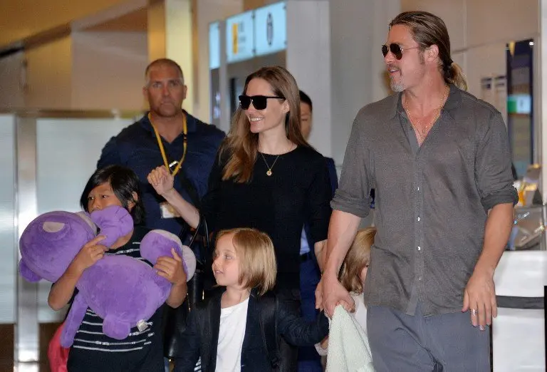 US film stars Brad Pitt (R) and Angelina Jolie (back C), accompanied by their children, arrive at Haneda International Airport in Tokyo on July 28, 2013. Pitt is now here for the promotion of his latest movie "World War Z". AFP PHOTO / Yoshikazu TSUNO / AFP PHOTO / YOSHIKAZU TSUNO