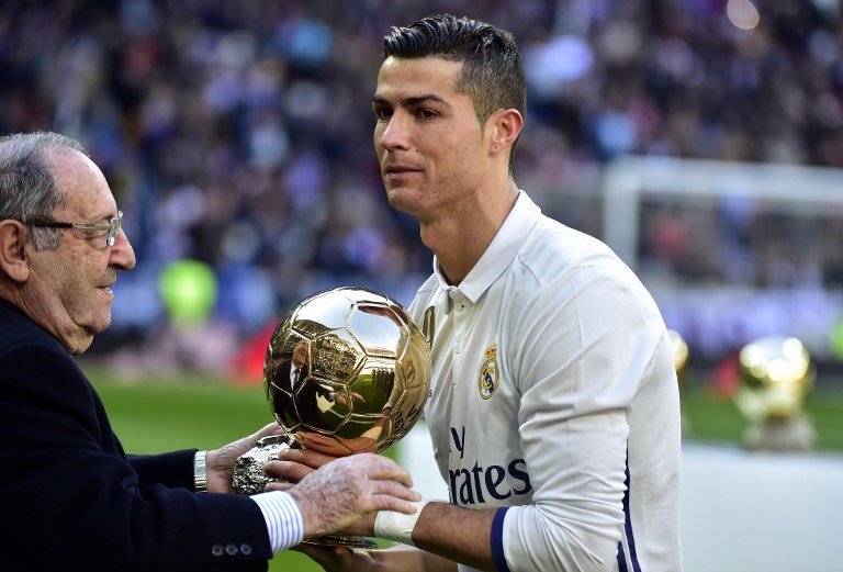 Former Real Madrid's Spanish player Francisco "Paco" Gento (L) handovers the Ballon d'Or at Real Madrid's Portuguese forward Cristiano Ronaldo during the handover ceremony of Ronaldo's Ballon d'Or 2016 before the Spanish league football match Real Madrid CF vs Granada FC at the Santiago Bernabeu stadium in Madrid on January 7, 2017.
Real Madrid won 5-0. / AFP PHOTO / GERARD JULIEN