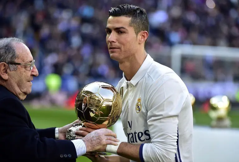 Former Real Madrid's Spanish player Francisco "Paco" Gento (L) handovers the Ballon d'Or at Real Madrid's Portuguese forward Cristiano Ronaldo during the handover ceremony of Ronaldo's Ballon d'Or 2016 before the Spanish league football match Real Madrid CF vs Granada FC at the Santiago Bernabeu stadium in Madrid on January 7, 2017.
Real Madrid won 5-0. / AFP PHOTO / GERARD JULIEN