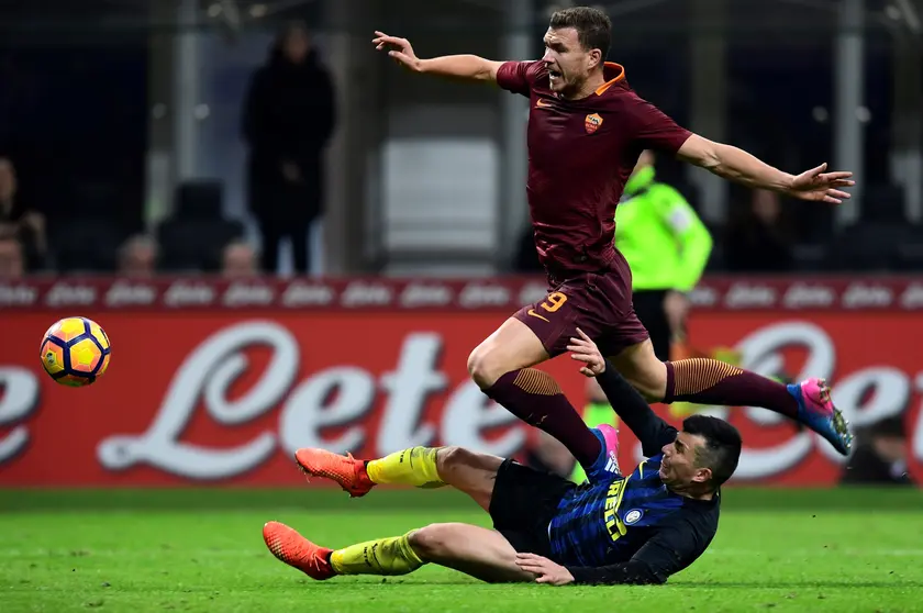 AS Roma's Bosnian forward Edin Dzeko (up) vies with Inter Milan's Chiliean midfielder Gary Medel during the Italian Serie A football match Inter Milan vs AS Roma at the San Siro stadium in Milan on February 26, 2017. / AFP PHOTO / MIGUEL MEDINA