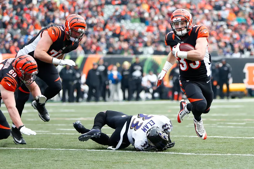 CINCINNATI, OH - JANUARY 1: Rex Burkhead #33 of the Cincinnati Bengals breaks a tackle by Matt Elam #33 of the Baltimore Ravens to score a touchdown during the first quarter at Paul Brown Stadium on January 1, 2017 in Cincinnati, Ohio. Michael Hickey/Getty Images/AFP