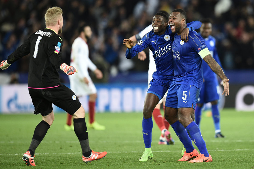 Leicester City's Nigerian midfielder Wilfred Ndidi (C), Leicester City's English-born Jamaican defender Wes Morgan (R) and Leicester City's Danish goalkeeper Kasper Schmeichel (L) celebrate their victory at the final whistle during the UEFA Champions League round of 16 second leg football match between Leicester City and Sevilla at the King Power Stadium on March 14, 2017. / AFP PHOTO / Oli SCARFF