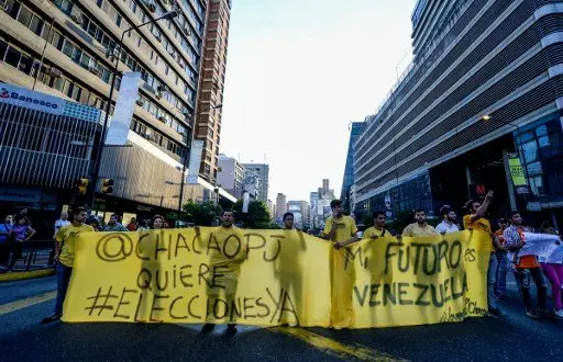 Venezuelan opposition activists, chanting slogans against the government of President Nicolas Maduro, march along a street of Caracas on March 31, 2017.
Venezuela's Supreme Court took over legislative powers Thursday from the opposition-majority National Assembly, whose speaker accused leftist President Nicolas Maduro of staging a "coup". / AFP PHOTO / FEDERICO PARRA