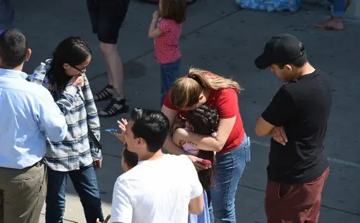 A woman hugs a girl after she and other North Park Elementary School students were released to their guardians following a shooting at the school which left two adults and one child dead, April 10, 2017 at Cajon High School in San Bernardino California.
A gunman opened fire at an elementary school in the California city of San Bernardino, killing one woman and wounding two students before turning the gun on himself, police said. The students were airlifted to a local hospital where their conditions were described as critical.
/ AFP PHOTO / Robyn Beck