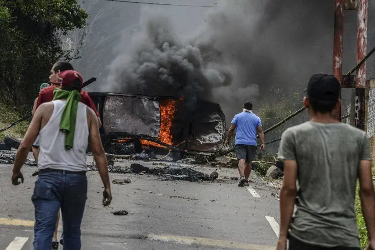 Venezuelan opposition activists set up barricades during a demonstration against President Nicolas Maduro in San Cristobal, on April 24, 2017. 
Protesters rallied on Monday vowing to block Venezuela's main roads to raise pressure on Maduro after three weeks of deadly unrest that have left 21 people dead. Riot police fired rubber bullets and tear gas to break up one of the first rallies in eastern Caracas early Monday while other groups were gathering elsewhere, the opposition said. / AFP PHOTO / George Castellanos