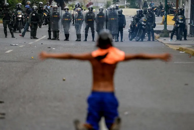 Opposition activists clash with riot police during a protest against President Nicolas Maduro in Caracas on April 26, 2017.
Venezuelan riot police fired tear gas to stop anti-government protesters from marching on central Caracas, the latest clash in a wave of unrest that, up to now, has left 26 people dead. / AFP PHOTO / FEDERICO PARRA