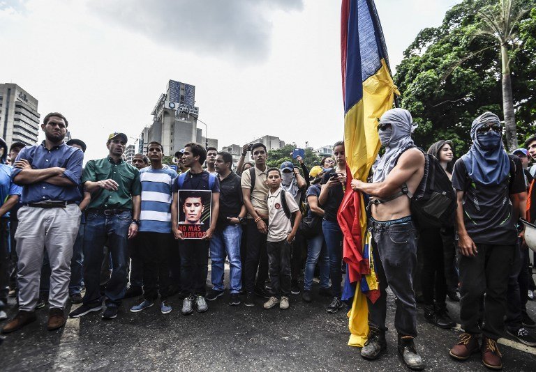 Venezuelan opposition leader Henrique Capriles takes part in a march paying tribute to student Juan Pablo Pernalete -killed on the eve by impact of a gas grenade during a protest against President Nicolas Maduro- in Caracas, on April 27, 2017. 
Venezuela defied international pressure over its deadly political crisis as European lawmakers accused its government of "brutal repression" and US President Donald Trump called the country "a mess". Nearly a month of clashes between anti-government protesters and the police have left 28 people dead, according to prosecutors. / AFP PHOTO / JUAN BARRETO